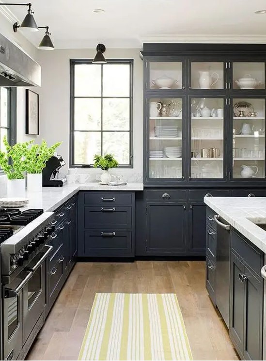 a graphite grey traditional kitchen with stainless steel accents and appliances and vintage lamps