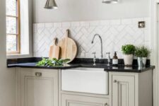 a lovely kitchen with herringbone tile backsplash