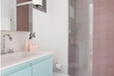a lovely neutral bathroom with dusty pink tiles in the shower and a mint floating vanity, some touches of pink here and there