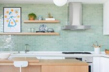 a mid-century modern white kitchen with a mint green tile backsplash, a stained kitchen island and open shelves