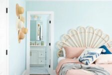 a mint blue bedroom with a bed with a creative headboard, pastel pink bedding and blue and pink pillows, a woven pendant lamp