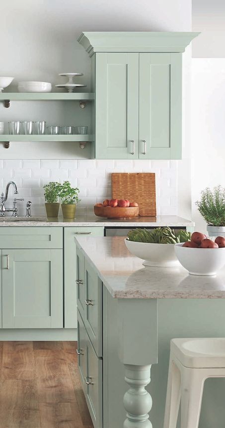a mint blue kitchen with shaker cabinets, neutral stone countertops, a white subway tile backsplash and open shelves