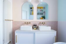 a modern bathroom in a mix of pastels – mint, blush and lilac, with pretty tiles, a modern vanity, a pink tub and a cool rug