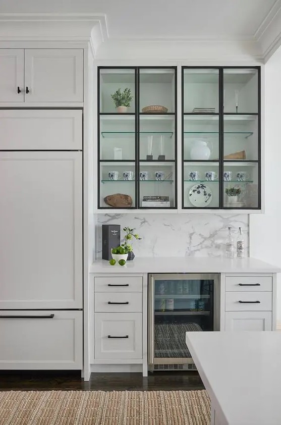 a modern white kitchen with black touches, flat, inlay and glass cabinets, black handles and black framing
