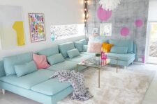 a neutral living room with a brushed accent wall, a mint blue sectional sofa with pillows, bold artwork and decorations