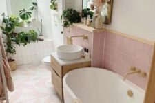 a pastel bathroom with pink and pink geo tiles, an oval tub, a floating vanity, a shower with potted greenery