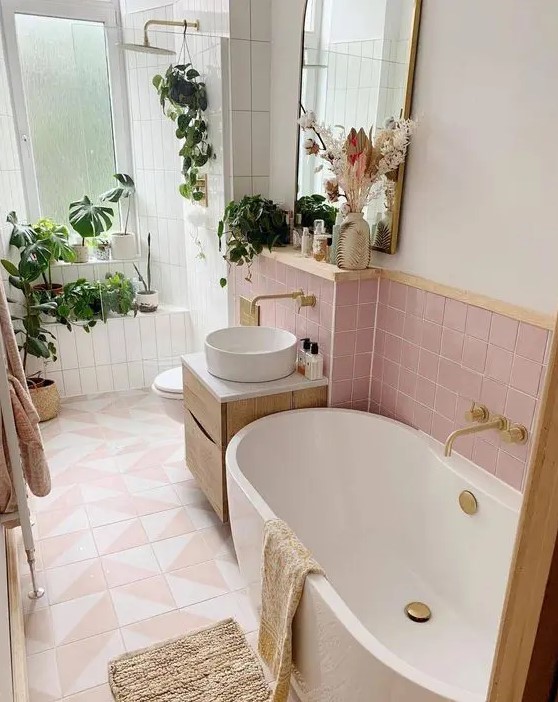 a pastel bathroom with pink and pink geo tiles, an oval tub, a floating vanity, a shower with potted greenery