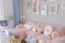 a pastel living room with grey walls, a pink sectional, blue curtains, a pink and blue rug and a stained coffee table