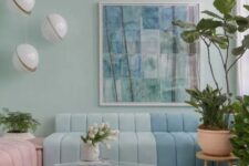 a pastel living room with mint blue walls, a color block floor, a color block blue sofa, a pink daybed, pendant lamps
