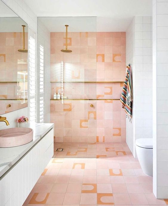 a pastel pink and white bathroom with a shower space with a niche, a floating white vanity, a pink sink and a large mirror