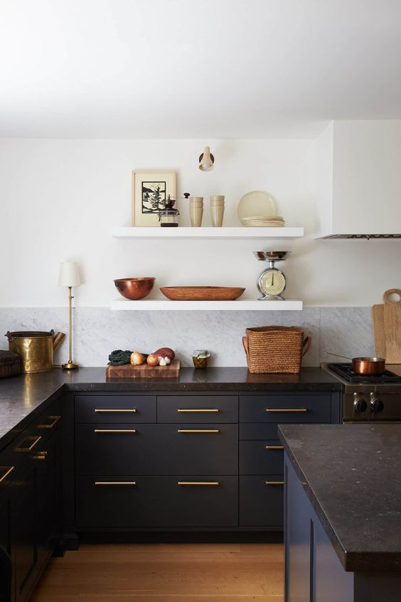 a refined vintage kitchen wiht navy flat panel cabinets, black granite countertops, open shelving and brass and gold touches