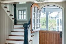 a rustic vintage entryway is made more special with a wood stained arched Dutch door with a glass insert