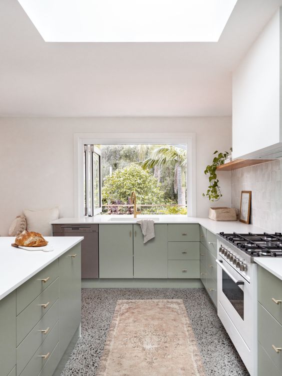 a sage green kitchen with flat panel cabinets, a white hood, an open shelf, a window instead of a backsplash