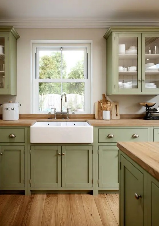 a sage green kitchen with shaker cabinets, butcherblock countertops, a large matching kitchen island is welcoming