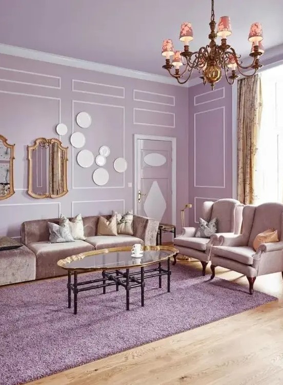 a sophisticated lilac living room with lilac walls and a ceiling, neutral seating furniture, a glass coffee table and a vintage chandelier