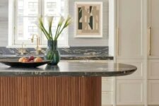 a sophisticated neutral kitchen with shaker cabinets, a stained fluted and curved kitchen island, black marble countertops
