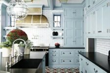 a vintage-inspired light blue kitchen with black countertops, a white tile backsplash, potted plants and a vintage hood