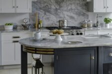 a vintage white kitchen with shaker cabinets and a large hood, a marble backsplash, a black curved kitchen island with open storage shelves
