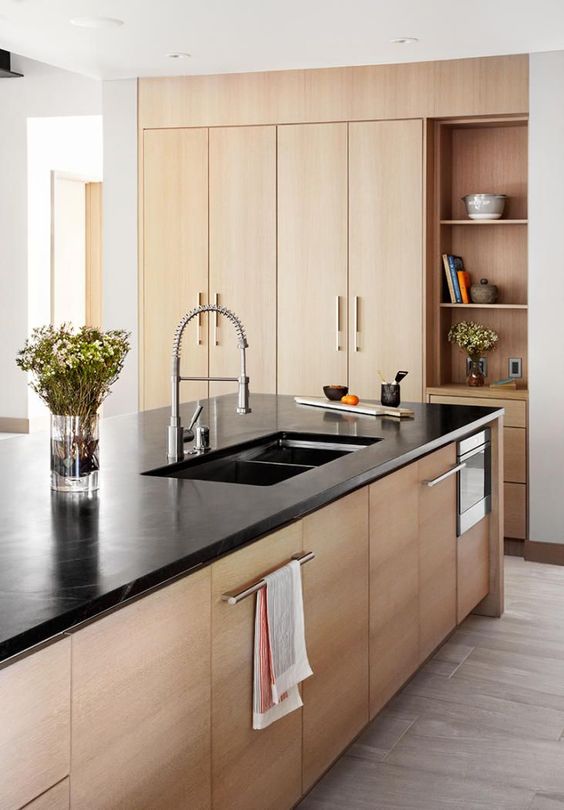a welcoming stained kitchen with built-in storage, a large kitchen island with a black countertop feels cool and cozy