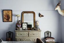 a whimsical vintage bedroom with lavender walls, vintage and shabby chic furniture, a vintage dresser with a mirror and a chic chanddelier