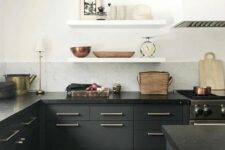 an elegant matte black kitchen with only lower cabinets, open shelves, black stone countertops and a large white hood