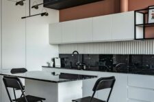 an elegant modern kitchen with white flat panel cabinets, black marble countertops and a backsplash, a small kitchen island with stools