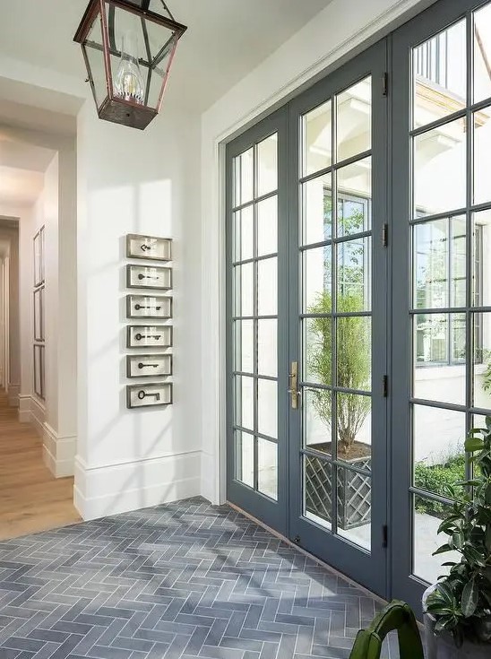 beautiful modern grey French doors and matching windows flood the entryway with light and make it look sophsiticated at the same time