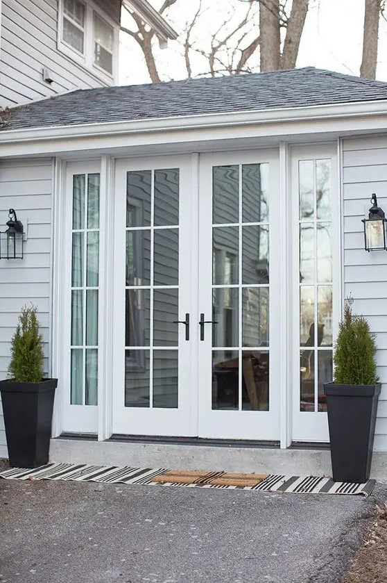 elegant white French doors with black handles are a very stylish and cool solution for any entrance, they look amazing and can be styled in many ways