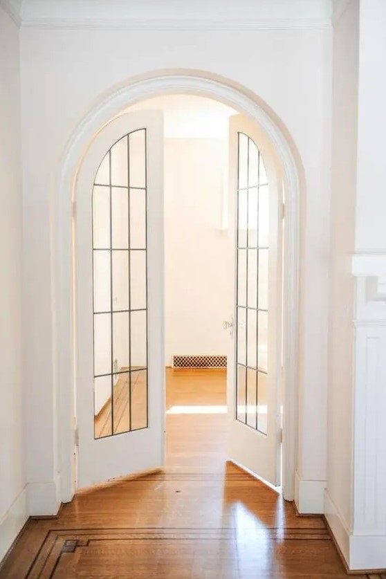 very chic and beautiful arched French doors with black frames and white base are an interesting and catchy solution for any space