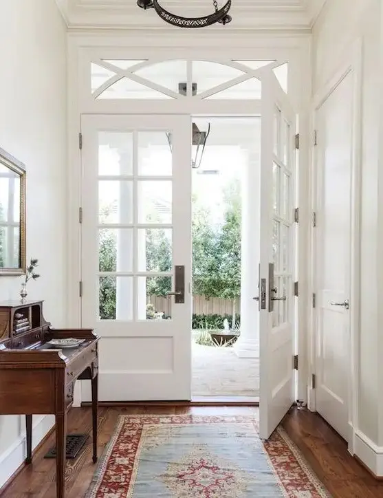 white French doors at the entrance are a very elegant and stylish idea that is timeless and can work for many decor styles