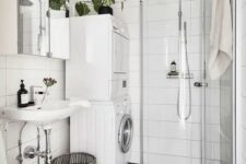 17 a black and white Scandinavian bathroom with white and black tiles, a shower in the corner, a washing machine and a dryer and a sink