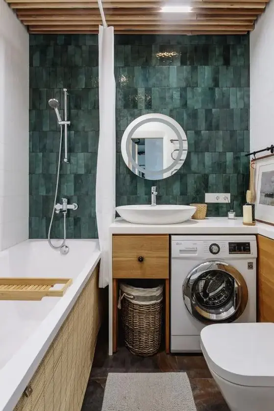 a bright and cool bathroom with a green skinny tile wall, a tub, a timber vanity with a built in washine machine