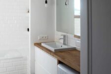 19 a contemporary black and white bathroom with a printed tile floor, white subway tiles, a floating vanity, a washing machine and pendant bulbs
