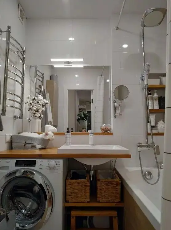a modern white bathroom with a bathtub, an open timber vanity with a washing machine, a mirror and built-in shelves