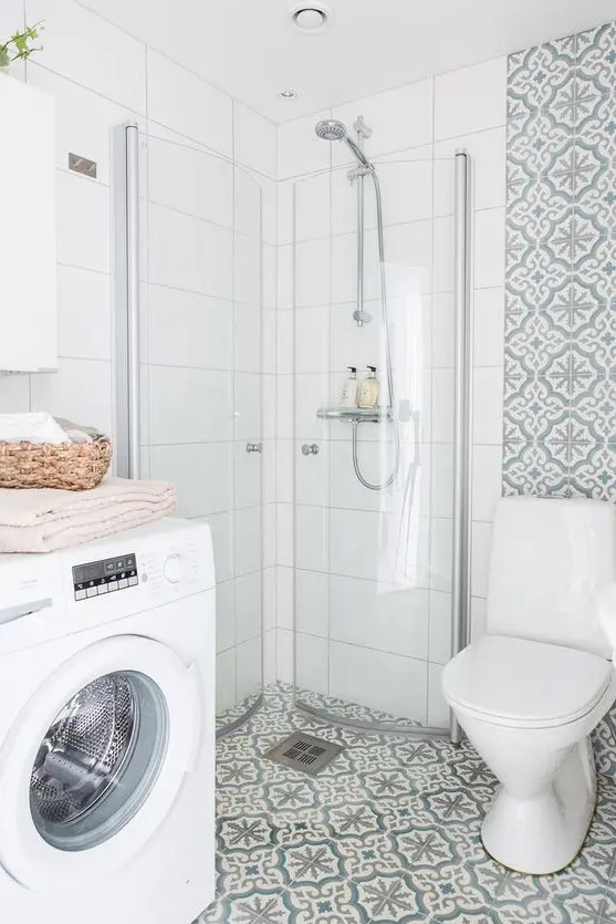a small and lovely neutral bathroom with printed and white squre tiles, a white toilet and a washing machine is airy and cool