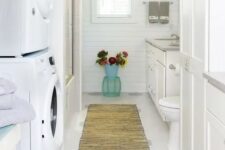 44 a white farmhouse bathroom clad with beadboard, with a large vanity, a bathtub and a stacked washing machine and a dryer