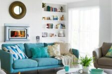 a Scandinavian living room with a turquoise sofa and a bold geo rug, a round table and some built-in shelves