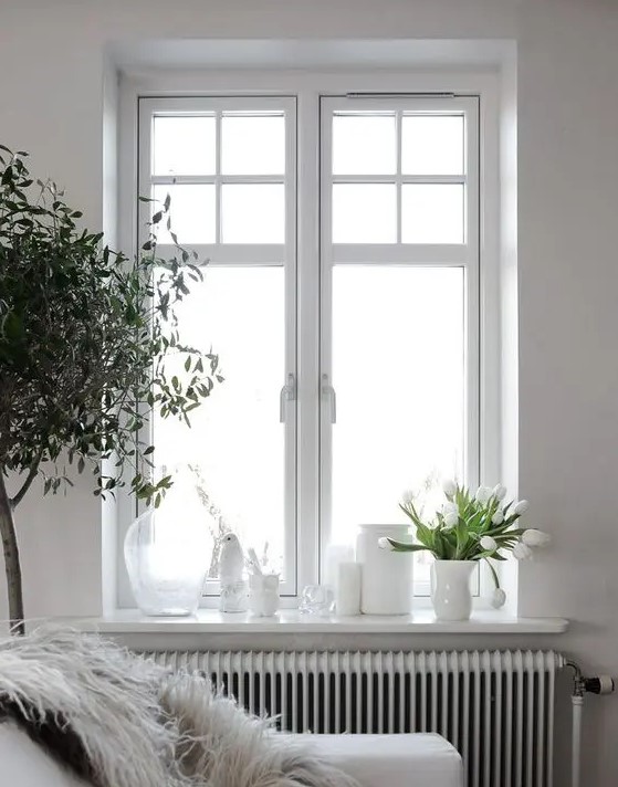 a Scandinavian space in white, with a casement window and a bit of paning for a cute touch is chic