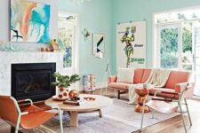 a beautiful and airy living room with mint green and lavender walls, a built-in fireplace, coral and amber furniture and a low coffee table