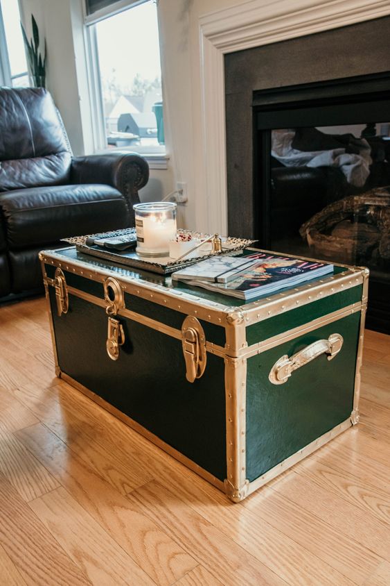 a beautiful dark green vintage trunk with brass detailing as a coffee table for a living room