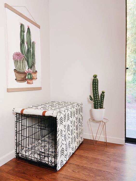 a black dog crate covered with printed fabric to achieve more privacy matches the boho interior with its print