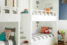 a bright kids’ bedroom with multiple built-in bunk beds and printed bedding, a printed rug, metal lamps and colorful toys