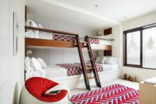 a bright kids’ room with multiple built-in bunk beds, bright textiles, a round chair and a neutral dresser