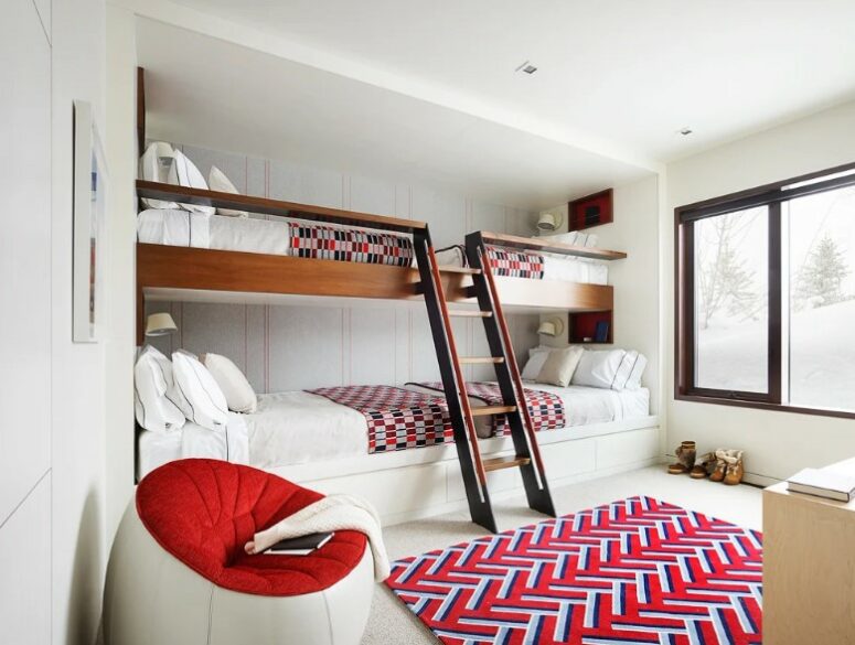 a bright kids' room with multiple built-in bunk beds, bright textiles, a round chair and a neutral dresser