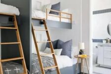 a catchy and contrasting graphite grey and white kids’ room with four built-in bunk beds, wooden ladders and a side table, a wooden pendant lamp