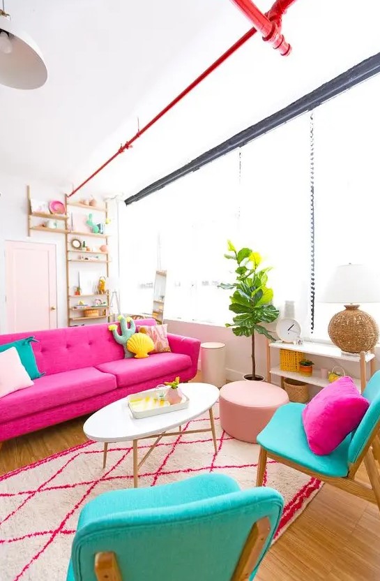 a cheerful living room with a hot pink sofa, turquoise chairs with quirky pillows, a printed rug, a potted plant and a blush pouf