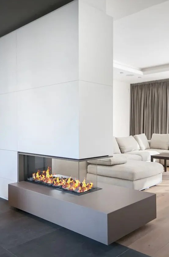 a chic contemporary living room with a neutral sofa, a dark coffee table, a minimalist fireplace and taupe curtains