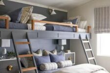 a chic kids’ room with built-in bunk beds, navy and grey bedding, ladders, elegant nightstands and pendant lamps