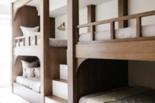 a chic modern rustic kids’ room with built-in multiple bunk beds and neutral bedding plus a ladder is a cool and lovely space to be in