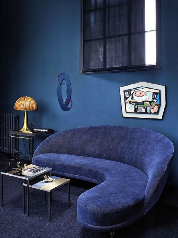 a classic blue room with a whimsy navy sofa, some artworks and side tables inspires with its beautiful shades